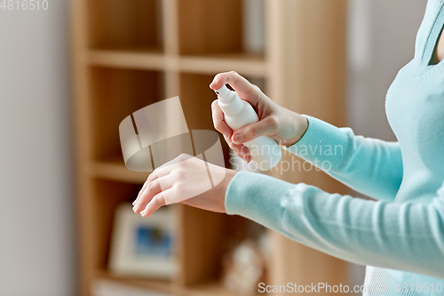 Image of close up of woman spraying hand sanitizer