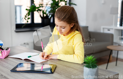 Image of student girl writing to notebook at home
