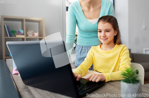 Image of mother and daughter with laptop doing homework