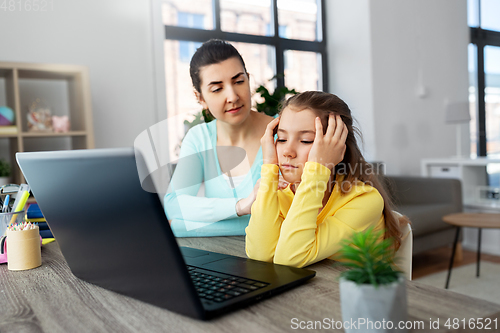 Image of mother and daughter with laptop doing homework