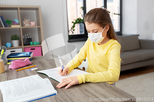 Image of student girl in medical mask learning at home