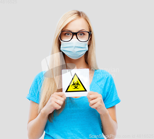 Image of woman in medical mask with boihazard caution sign