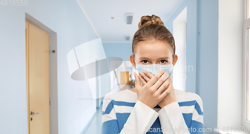 Image of teenage girl in protective medical mask at school