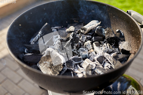 Image of charcoal smoldering in brazier outdoors