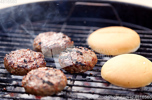 Image of burger meat cutlets roasting on barbecue grill