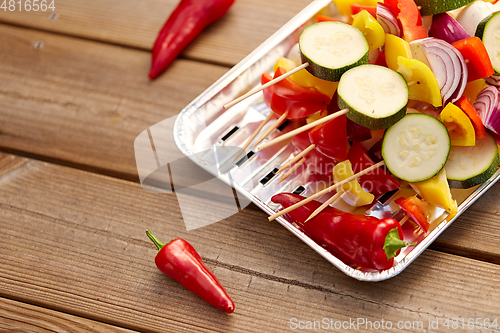 Image of close up of vegetables on skewers on foil grill