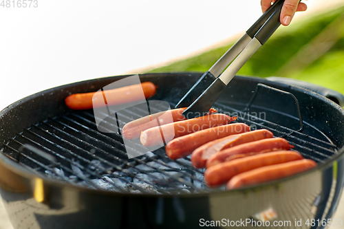 Image of meat sausages roasting on hot brazier grill