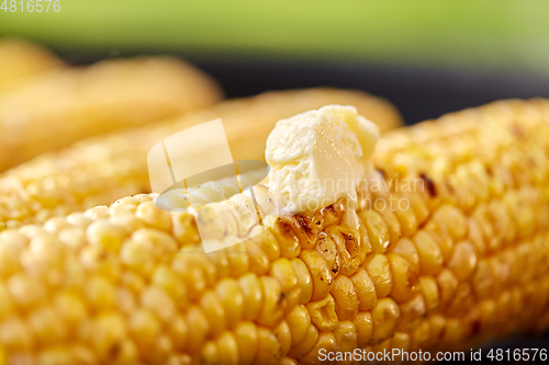 Image of close up of corn with butter roasting on grill