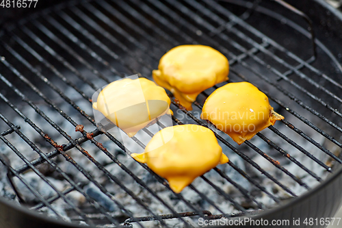 Image of close up of meat cutlet with cheese on grill