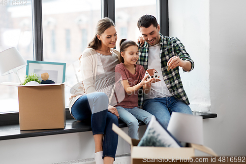 Image of happy family with house model moving to new home