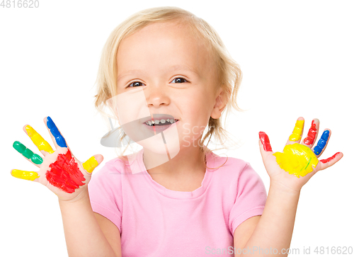 Image of Portrait of a cute little girl playing with paints