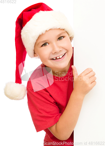Image of Little girl in santa hat is holding blank board