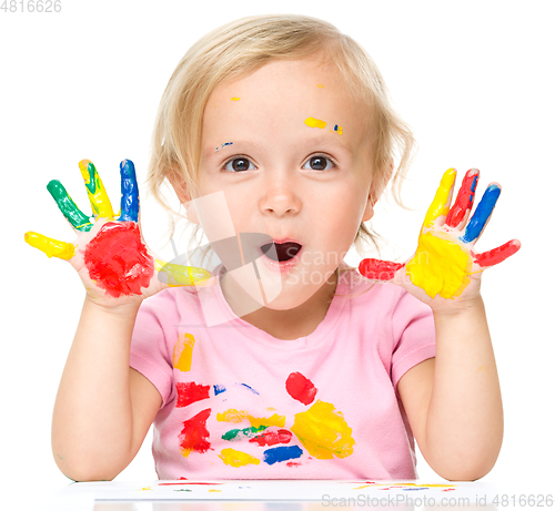 Image of Portrait of a cute little girl playing with paints