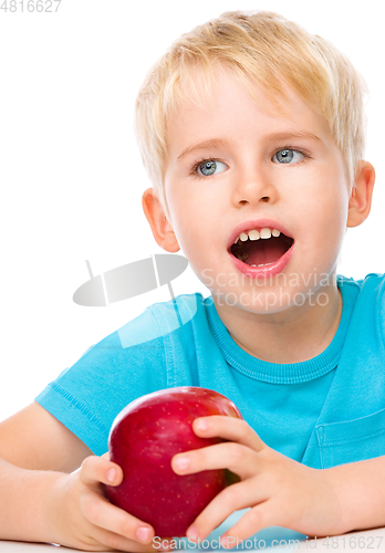 Image of Portrait of a cute little boy with red apple