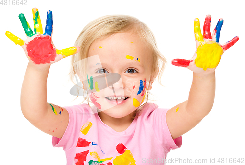 Image of Portrait of a cute little girl playing with paints