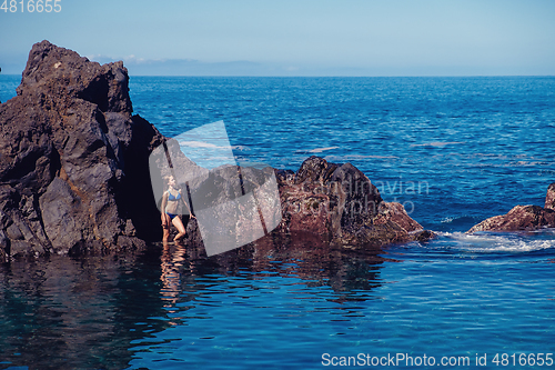 Image of beautiful girl resting in natural ocean swimming pool