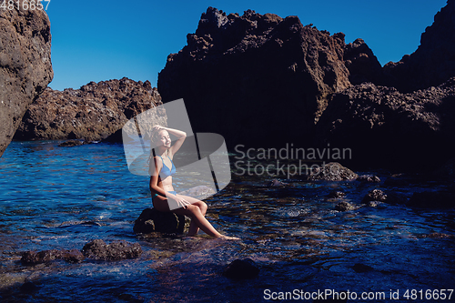 Image of beautiful girl resting in natural ocean swimming pool