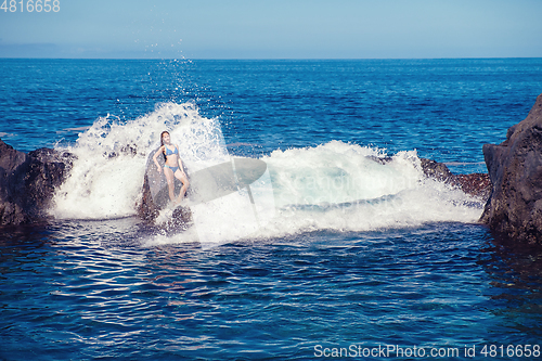 Image of beautiful girl resting in natural ocean swimming pool