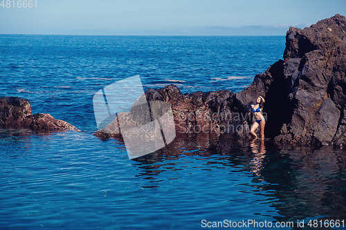 Image of beautiful girl resting in natural ocean swimming pool