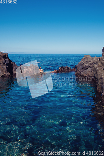 Image of beautiful girl resting in natural ocean swimming pool