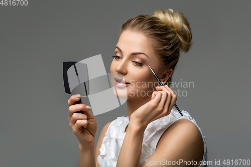 Image of beautiful girl applying makeup