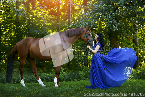 Image of beautiful girl in dress with horse