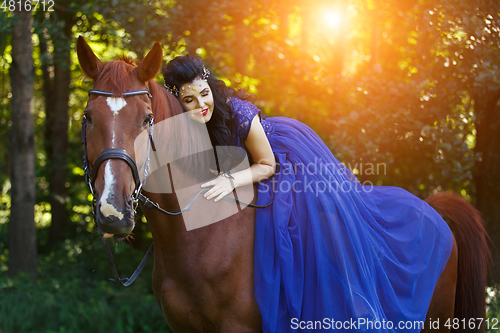 Image of beautiful girl in dress with horse