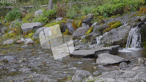 Image of Big beautiful waterfall flows down the rocks mountains