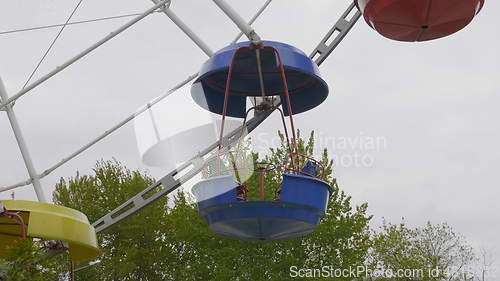 Image of Underside view of a ferris wheel over blue sky.