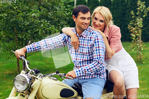 Image of beautiful couple on retro motorbike