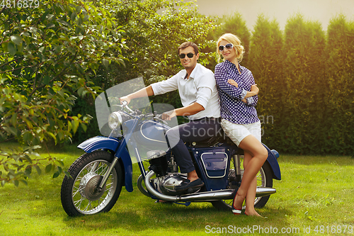 Image of beautiful couple on retro motorbike
