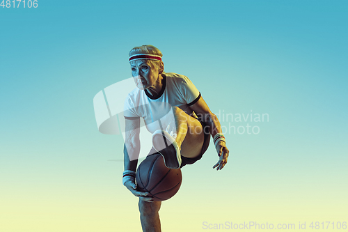 Image of Senior woman playing basketball in sportwear on gradient background in neon light