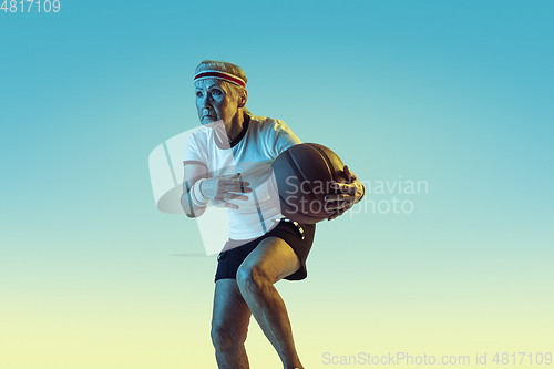 Image of Senior woman playing basketball in sportwear on gradient background in neon light