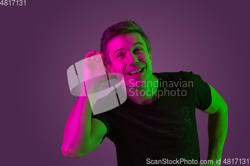 Image of Caucasian man\'s portrait isolated on purple studio background in neon light