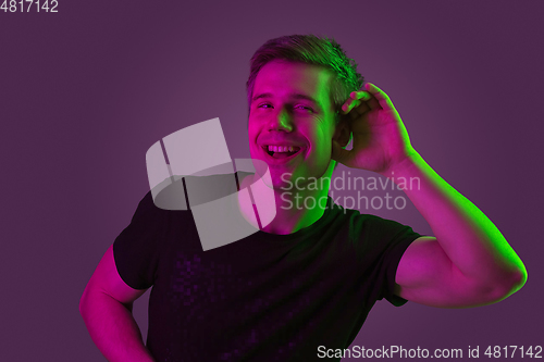 Image of Caucasian man\'s portrait isolated on purple studio background in neon light