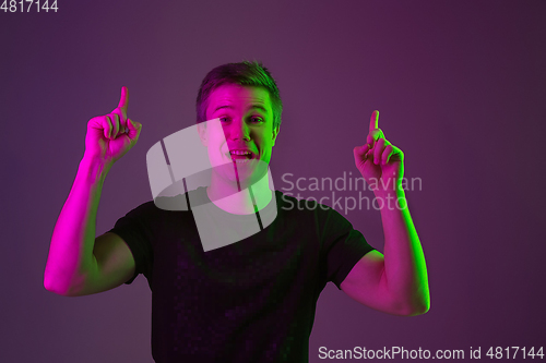 Image of Caucasian man\'s portrait isolated on purple studio background in neon light