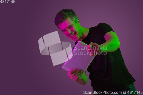 Image of Caucasian man\'s portrait isolated on purple studio background in neon light