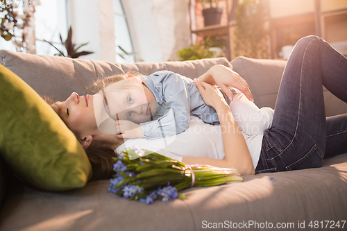 Image of Family time. Mother and daughter having time together at home, look happy and sincere