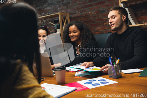 Image of Colleagues working together in modern office using devices and gadgets during creative meeting