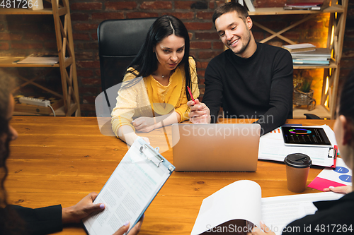 Image of Colleagues working together in modern office using devices and gadgets during creative meeting