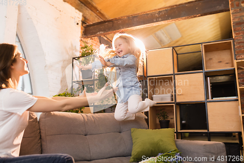 Image of Family time. Mother and daughter having time together at home, look happy and sincere