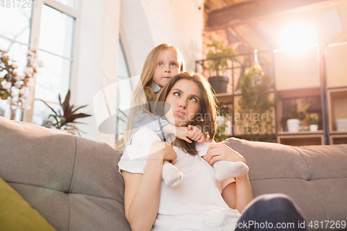 Image of Family time. Mother and daughter having time together at home, look happy and sincere