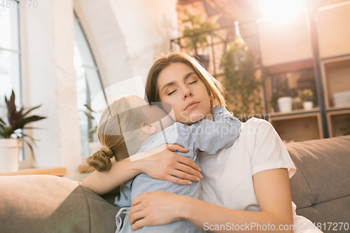 Image of Family time. Mother and daughter having time together at home, look happy and sincere