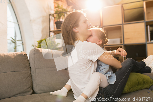 Image of Family time. Mother and daughter having time together at home, look happy and sincere