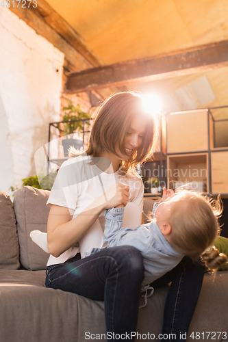 Image of Family time. Mother and daughter having time together at home, look happy and sincere