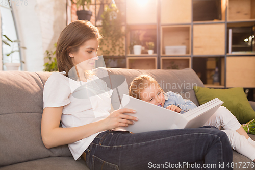 Image of Family time. Mother and daughter having time together at home, look happy and sincere