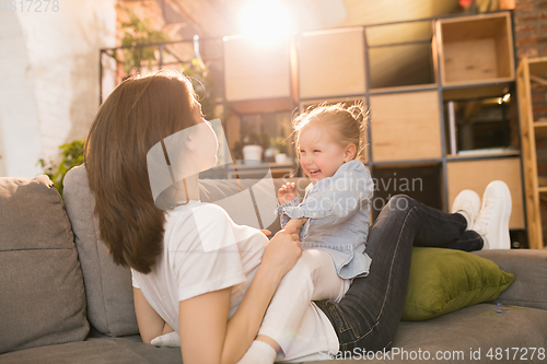 Image of Family time. Mother and daughter having time together at home, look happy and sincere