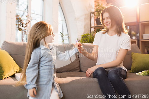 Image of Family time. Mother and daughter having time together at home, look happy and sincere