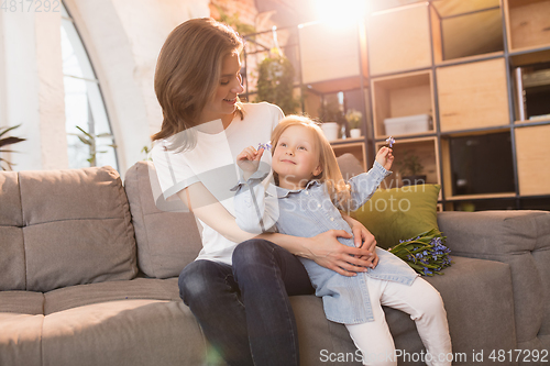 Image of Family time. Mother and daughter having time together at home, look happy and sincere