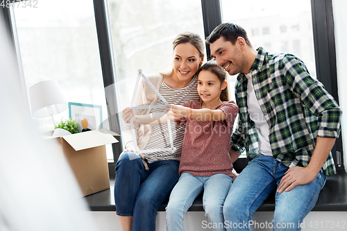 Image of happy family with folding ruler moving to new home